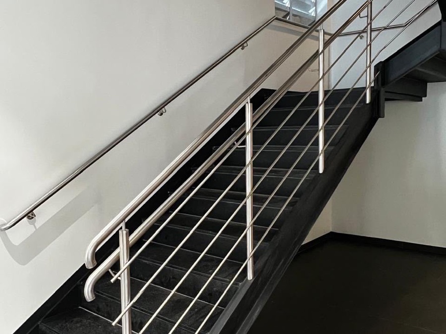 Corrimão contínuo de inox em escada de emergência de prédio comercial