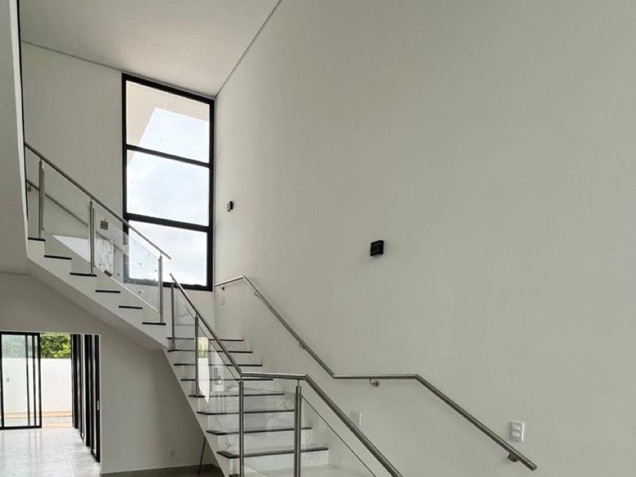 Corrimão duplo de inox com guarda-corpo de vidro em escada de mármore