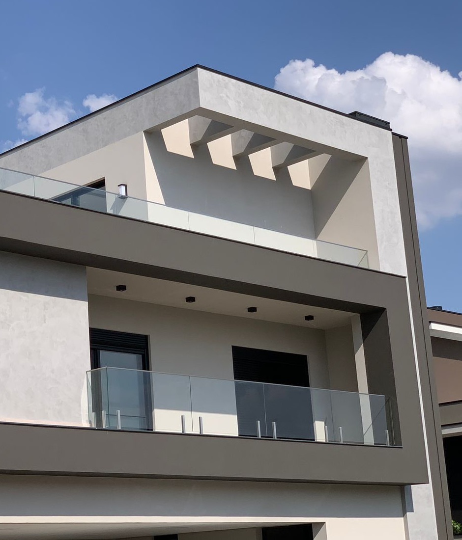 Fachada de residência de alto padrão com guarda-corpo de vidro em dois pavimentos, instalado pela Inox Conceito