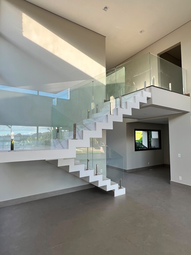 Escada com guarda-corpo de vidro e corrimão de inox, fabricados e instalados pela Inox Conceito